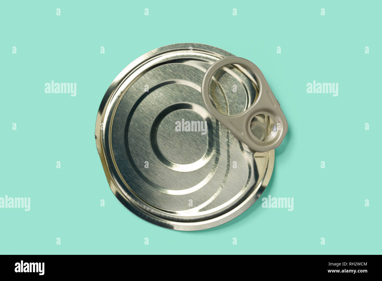 Removed lid of tin can with pull ring on green teal background, clipping path included Stock Photo