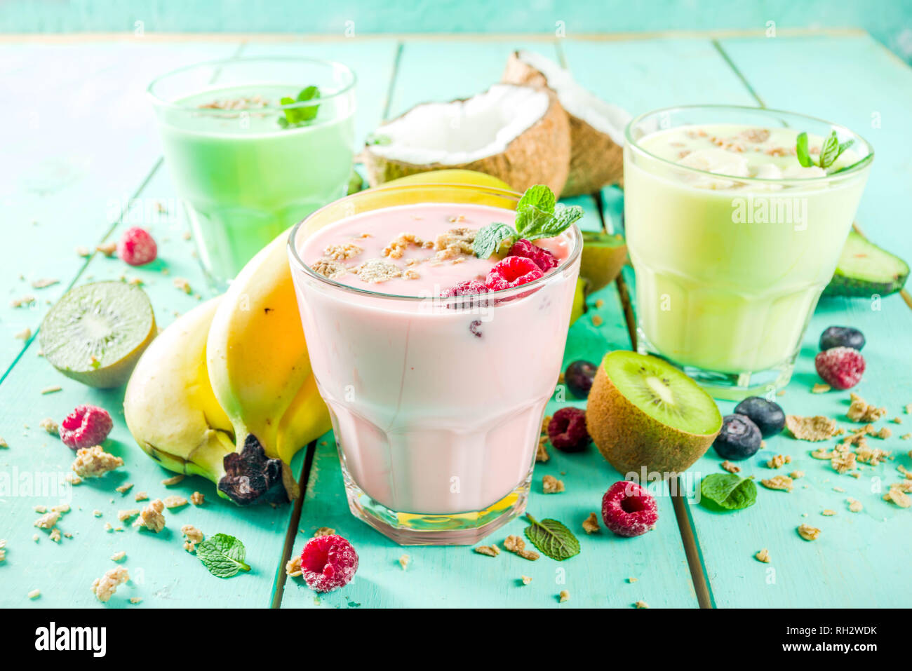 Summer refreshing drinks - protein shakes, milkshakes or smoothies, with fresh berry and fruits, light blue table copy space Stock Photo