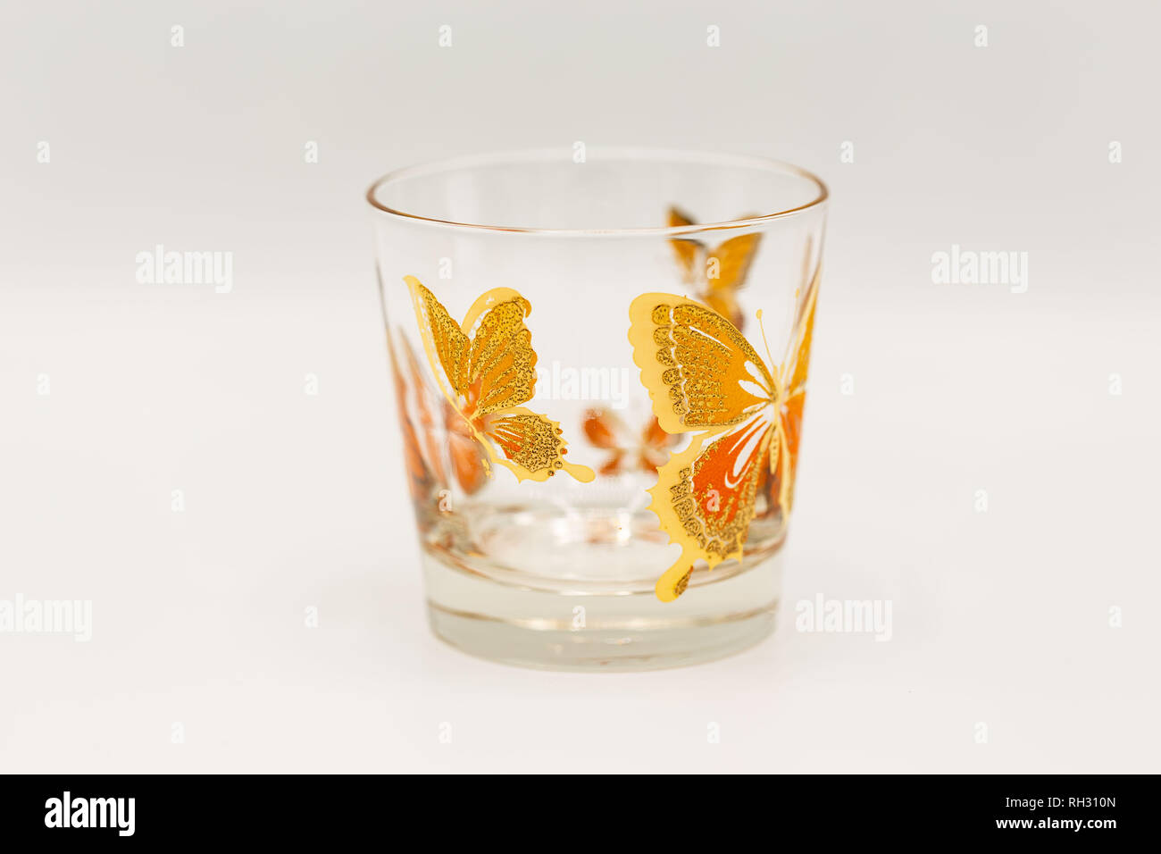 a short drinking glassware that has butterflies painted on them Stock Photo
