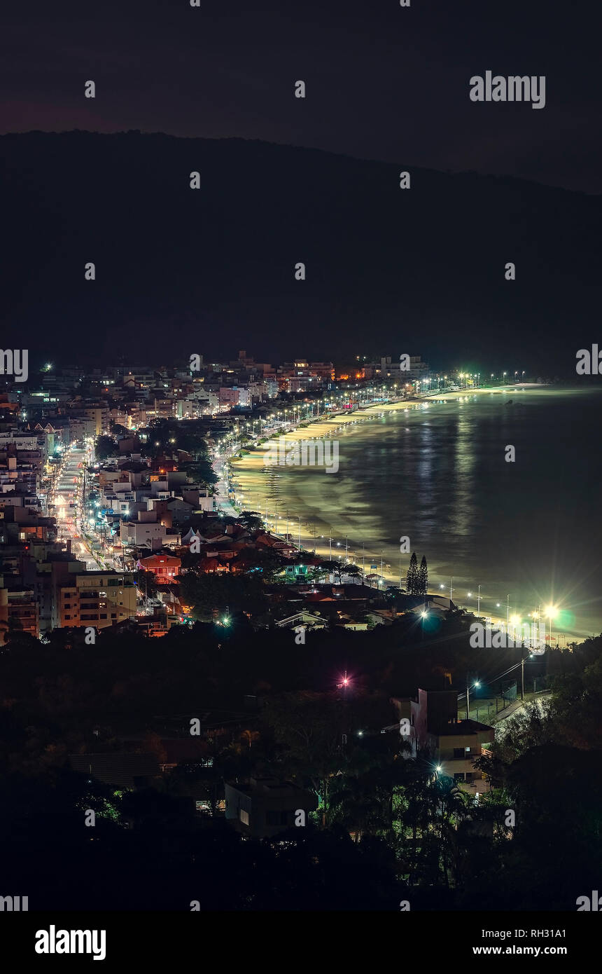 Bombinhas at night, the city and Praia de Bombas. Touristic season, city buildings, main avenue Leopoldo Zarling and Bombas beach. Stock Photo