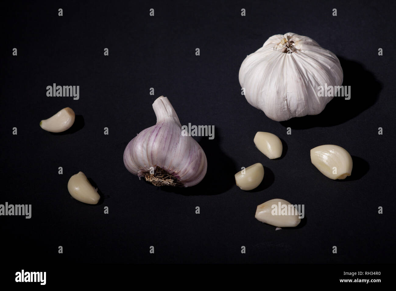 Garlic cloves on black background Stock Photo - Alamy
