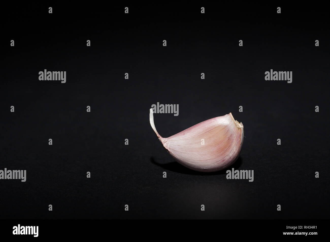 Garlic cloves on black background Stock Photo - Alamy