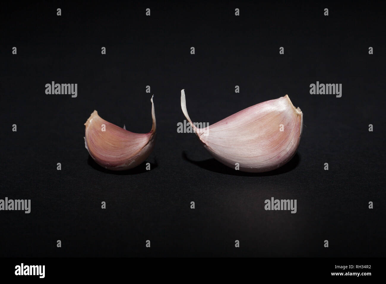 Garlic cloves on black background Stock Photo - Alamy