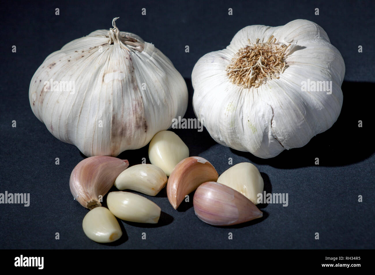 Garlic on black background. Garlic head and cloves Stock Photo - Alamy