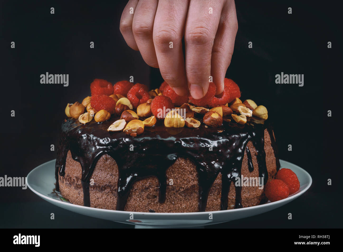 Pastry Chef In The Kitchen Decorating A Chocolate Cake Of