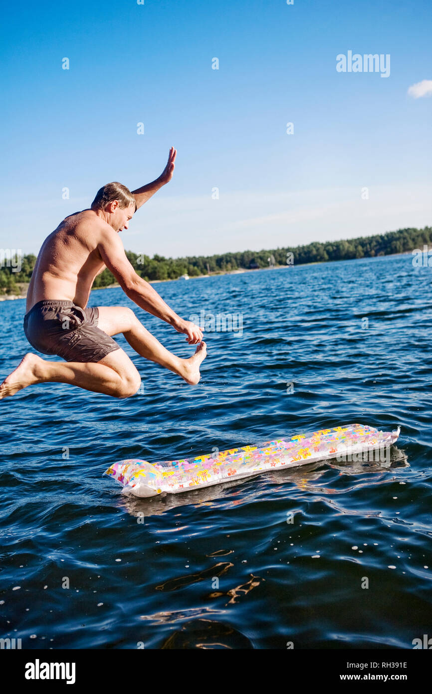 Man jumping in water Stock Photo