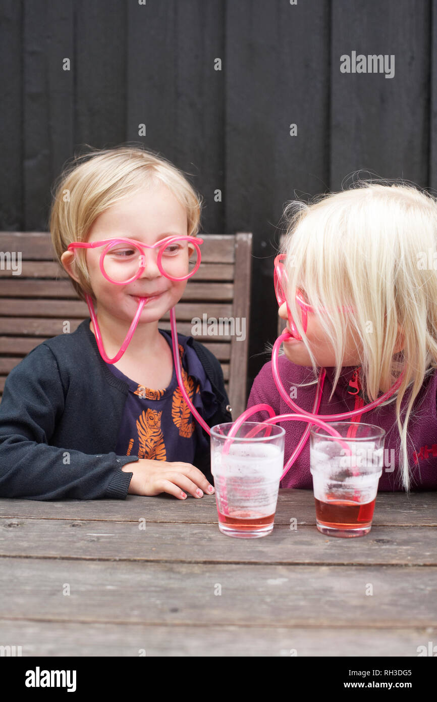 Girls drinking through straw eyeglasses Stock Photo Alamy