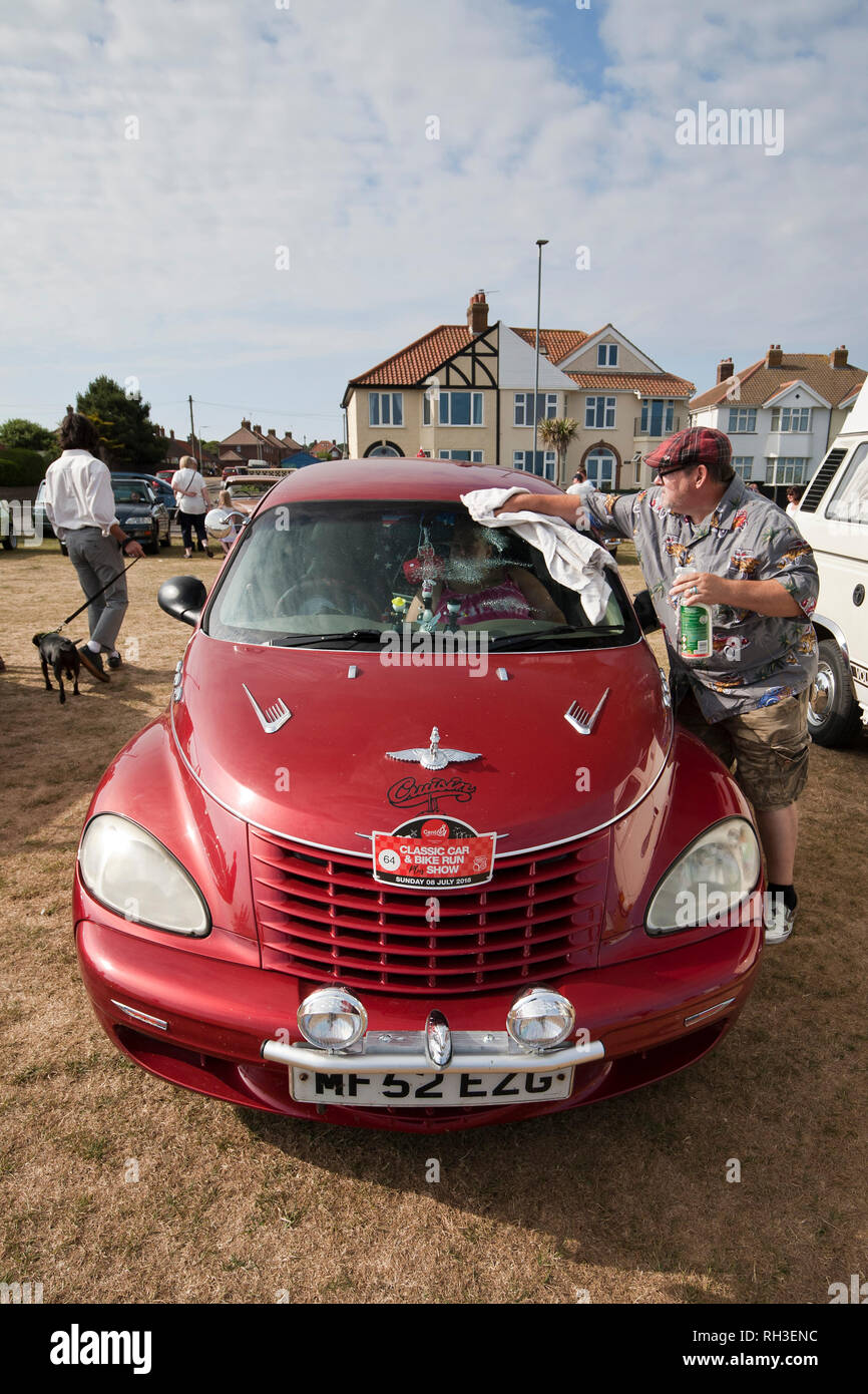 Owner of a classic Chrysler Cruiser gives a quick polish before his run from Cromer to Great Yarmouth for an annual charity fund-raising event. Stock Photo