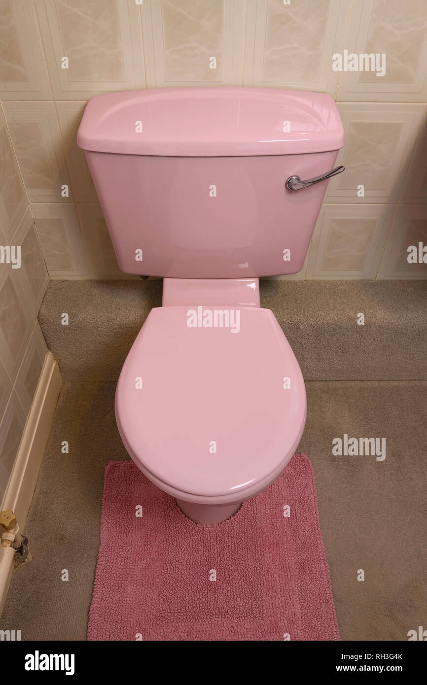 An old fashioned pale pink coloured bathroom toilet Stock Photo