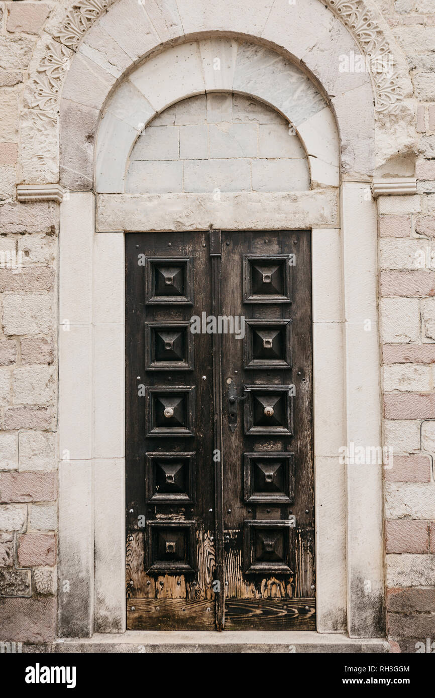 A closed old wooden door at the entrance to the building. Stock Photo