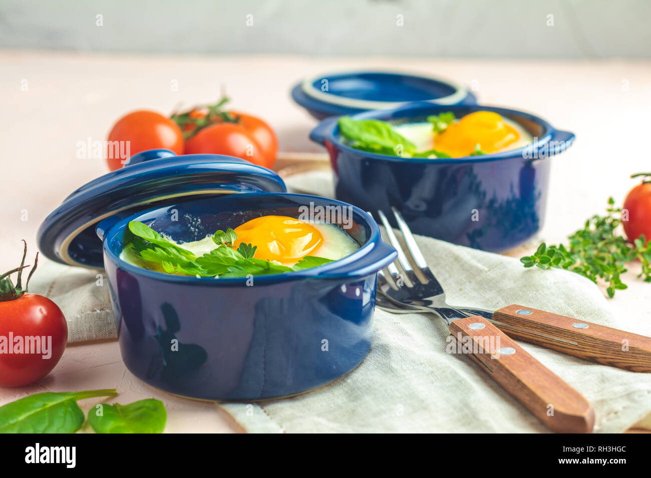 Eggs kokot cocotte french breakfast. Baked eggs in blue ceramic baking  molds. Portioned casserole from vegetables and eggs in Italian style Stock  Photo - Alamy