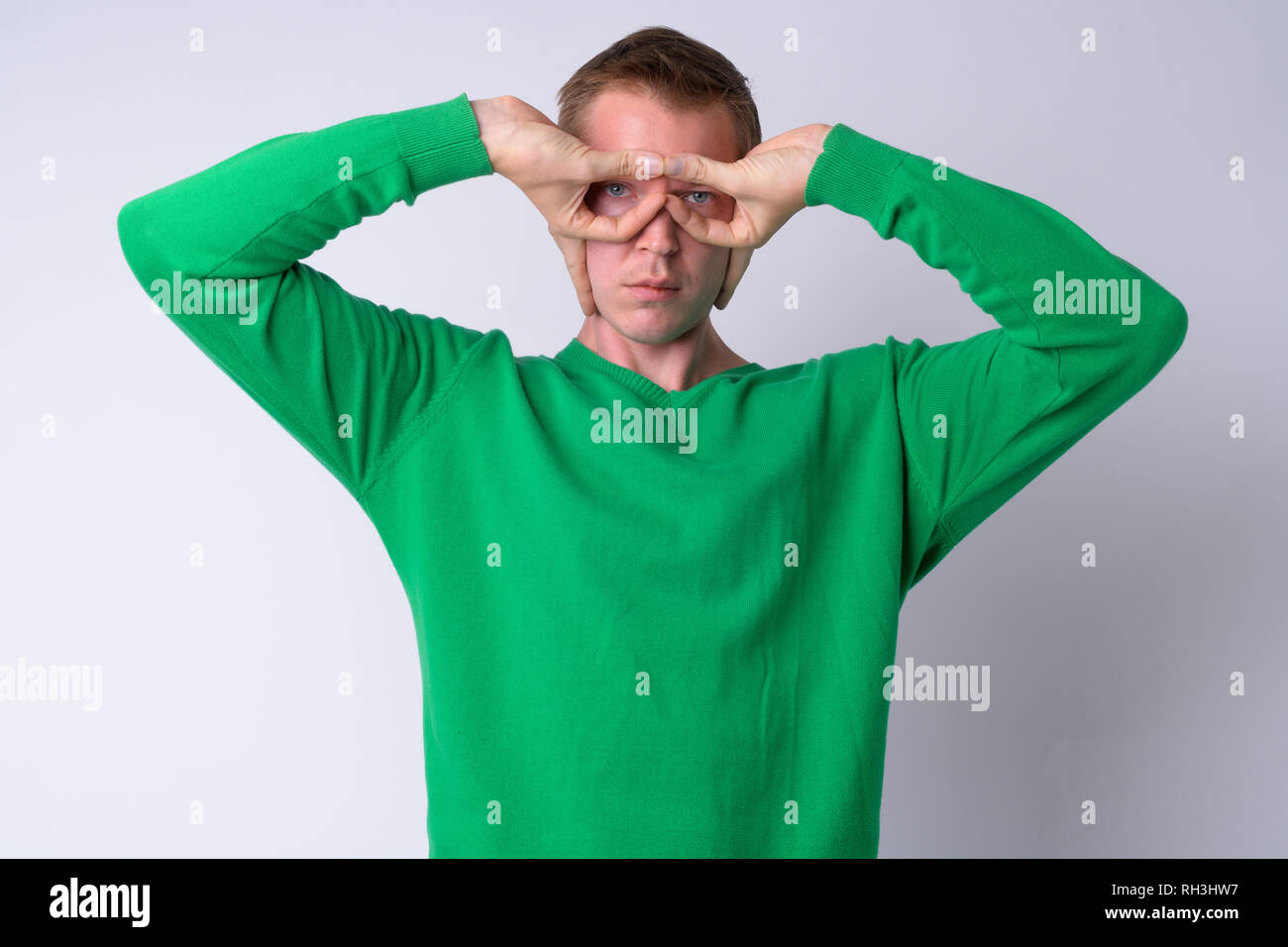 Portrait of young handsome man using fingers as batman Stock Photo