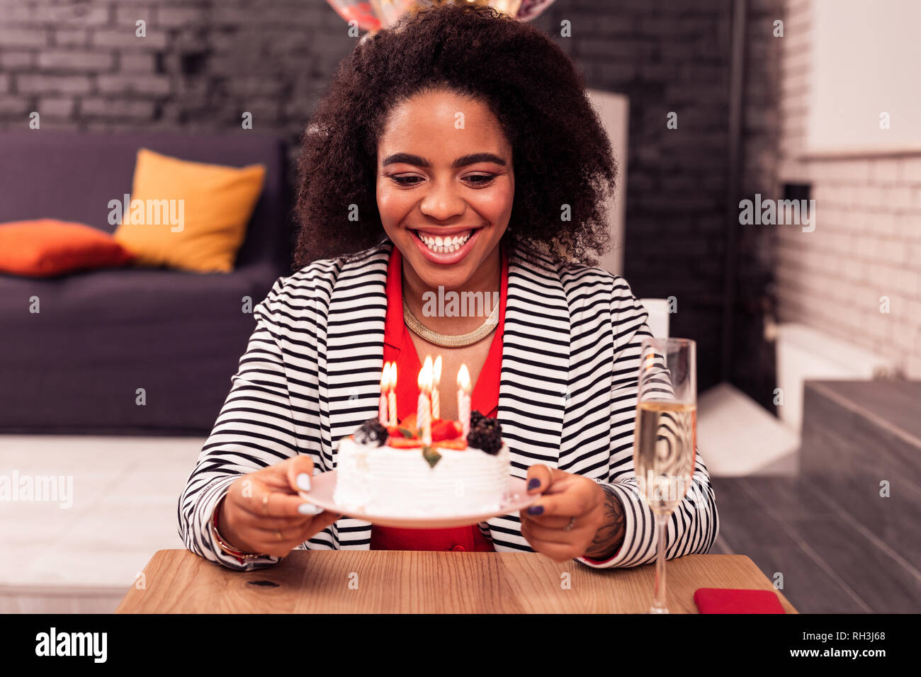 Joyful attractive woman holding a plate with cake Stock Photo
