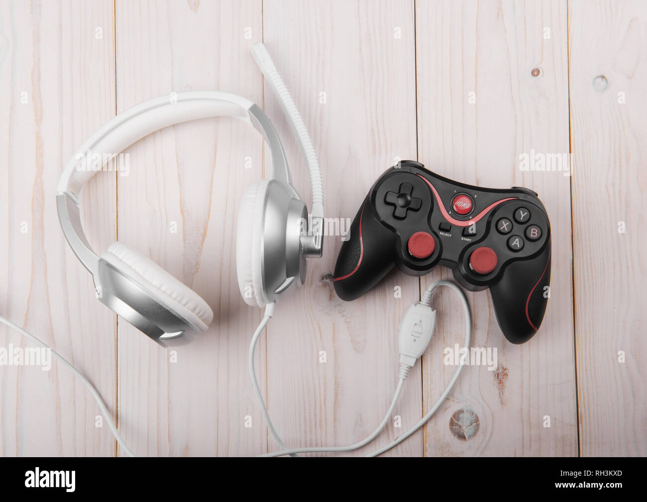 remote and headphones for video games on a light wooden background Stock Photo