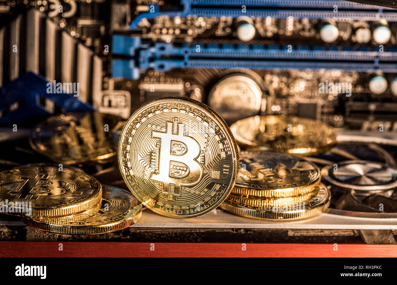 Shiny physical bitcoins and record-keeping equipment. Mining farm. Stock Photo