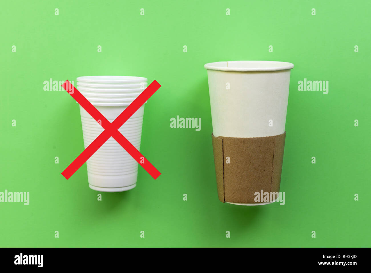 White single-use plastic and paper cup on a green background. The concept  of choice without plastic or environmental problems Stock Photo - Alamy