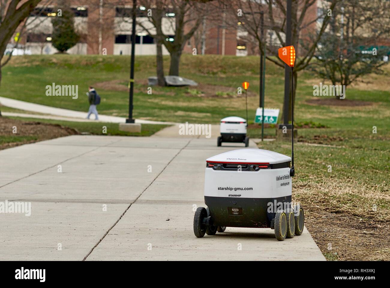 Fairfax, Virginia, USA - January 29, 2019: Two autonomous food delivery robots travel enroute to customers on George Mason University's main campus. Stock Photo