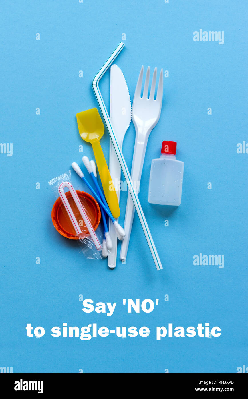 White singleuse plastic and plastic drink straws on a blue background