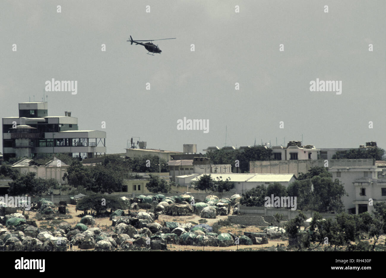 13th October 1993 A U.S. Army OH-58 Kiowa Scout Observation helicopter flies low above a tented refugee camp near the K4 roundabout in Mogadishu, Somalia. Stock Photo