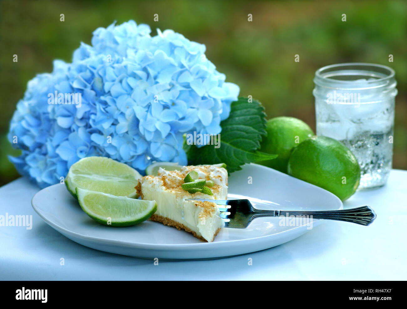 Key lime pie, served outside with lime slices and water, makes a cool summer treat in the Deep South. Stock Photo