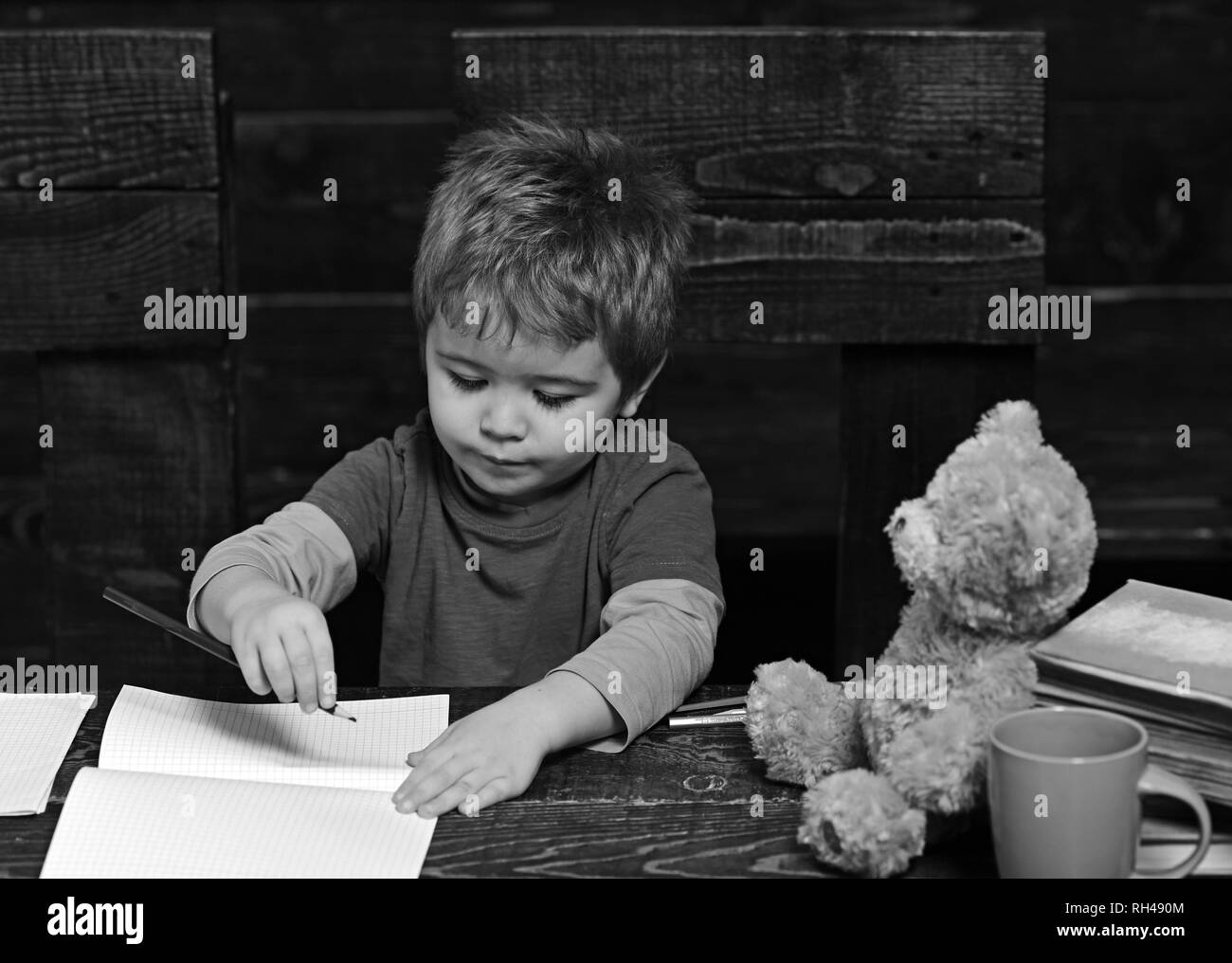 small-kid-writing-in-textbook-diligent-boy-learning-letters-early