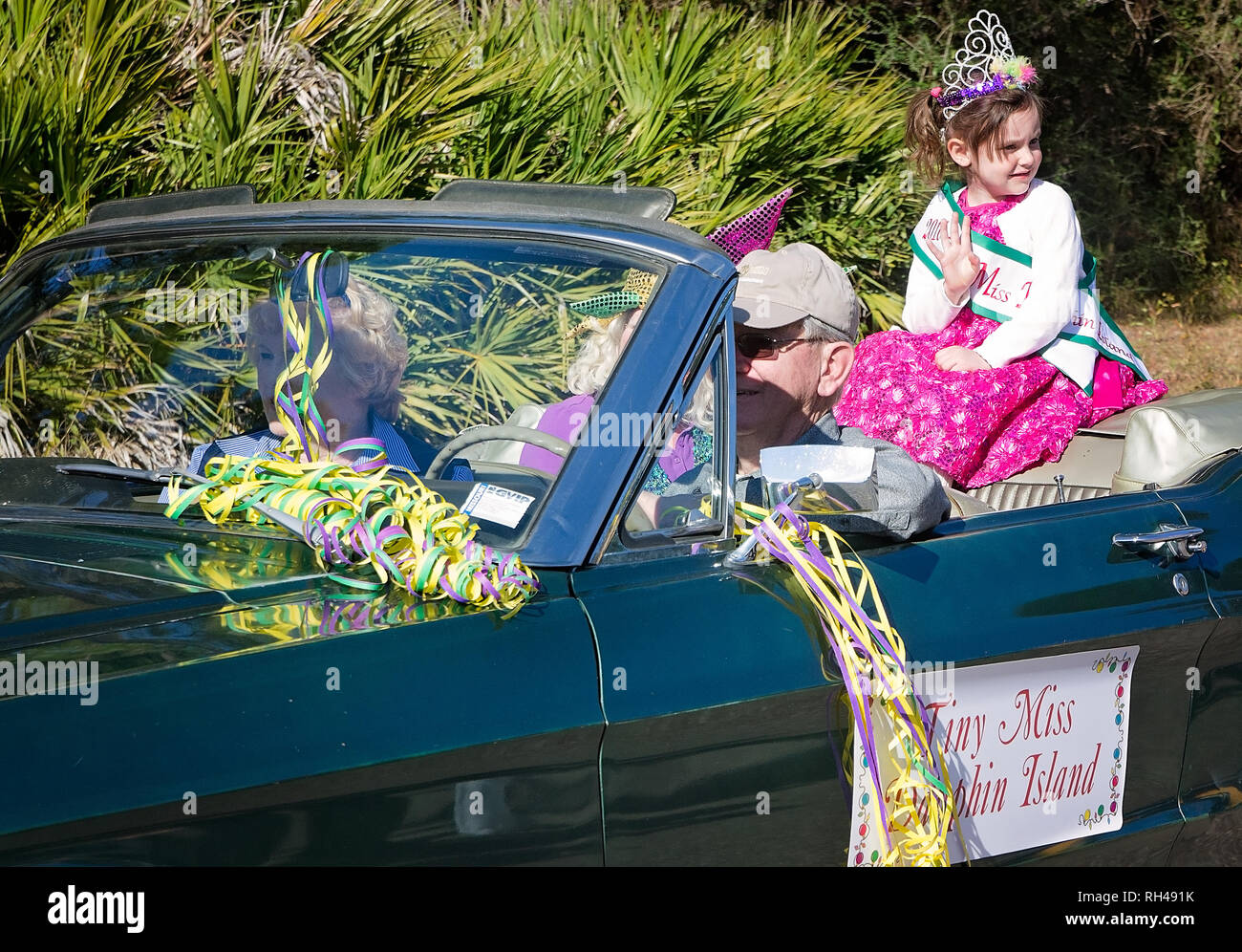Tiny Miss Dauphin Island waves to the crowd as she rides in Dauphin Island’s first People’s Parade during Mardi Gras, Feb. 4, 2017, Stock Photo
