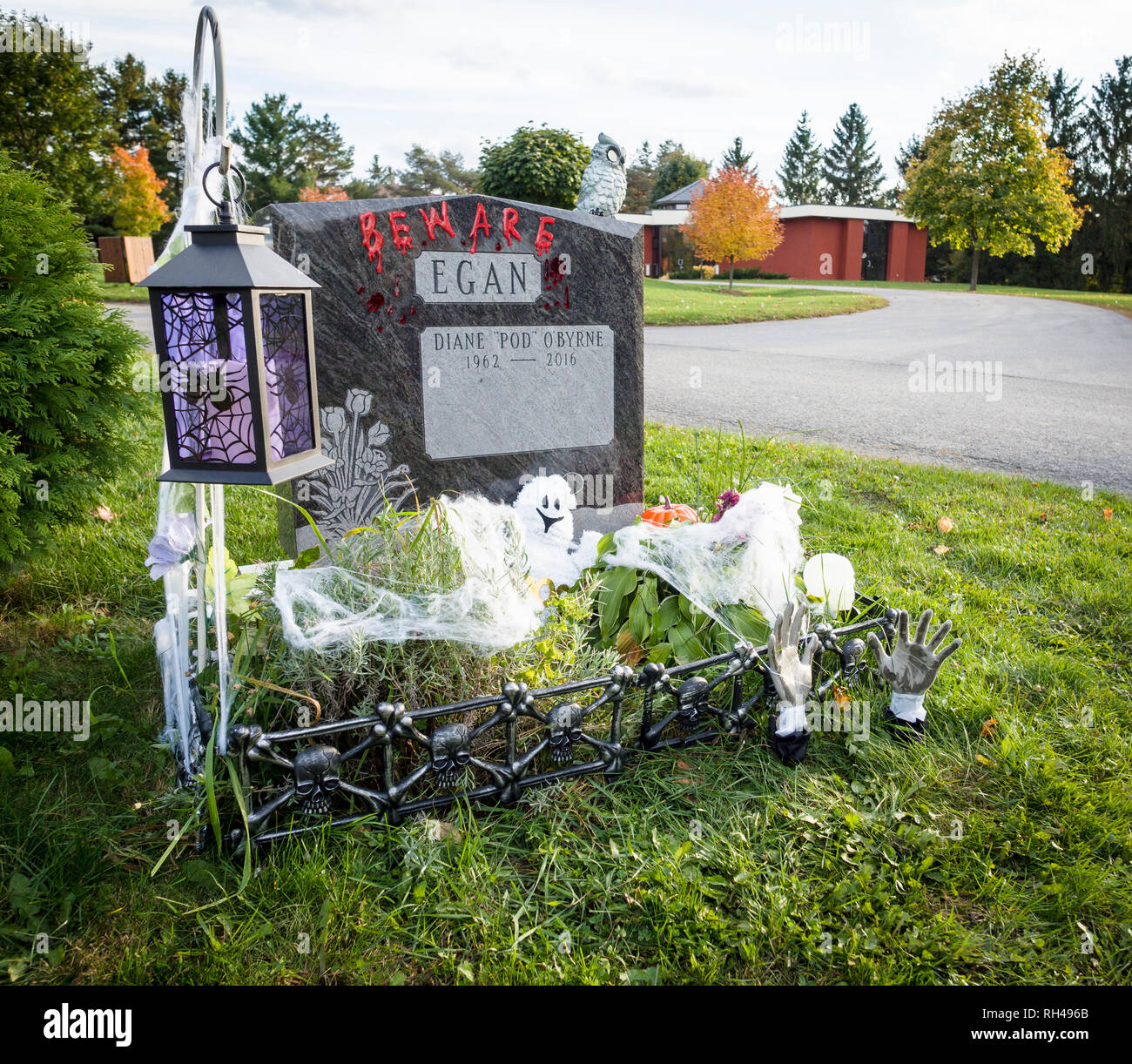 Grave decorated for Halloween: A graves stone of Diane O'byrne Egan decorated with BEWARE written in fake blood and other kitchy halloween items. Stock Photo