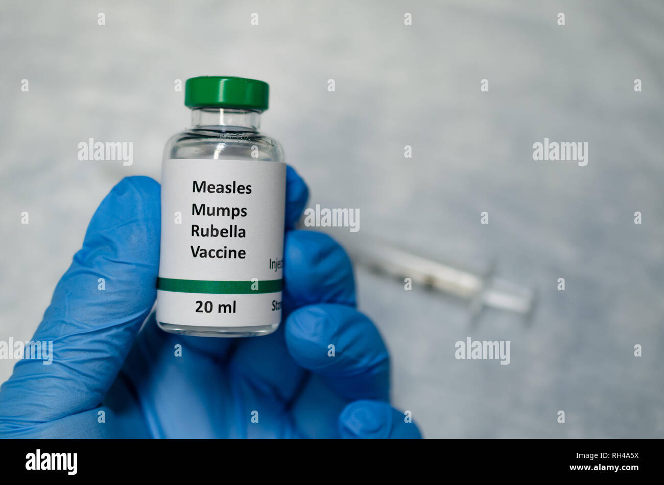 Measles, mumps and rubella combined vaccine vial with injection syringe Stock Photo