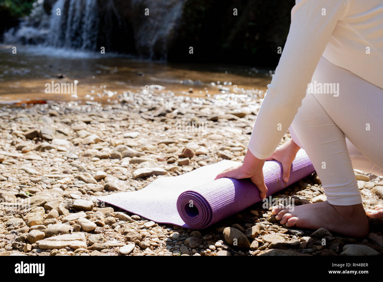 Beautiful girls are playing yoga at the park. Among the natural waterfalls in the forest, exercise concepts Stock Photo