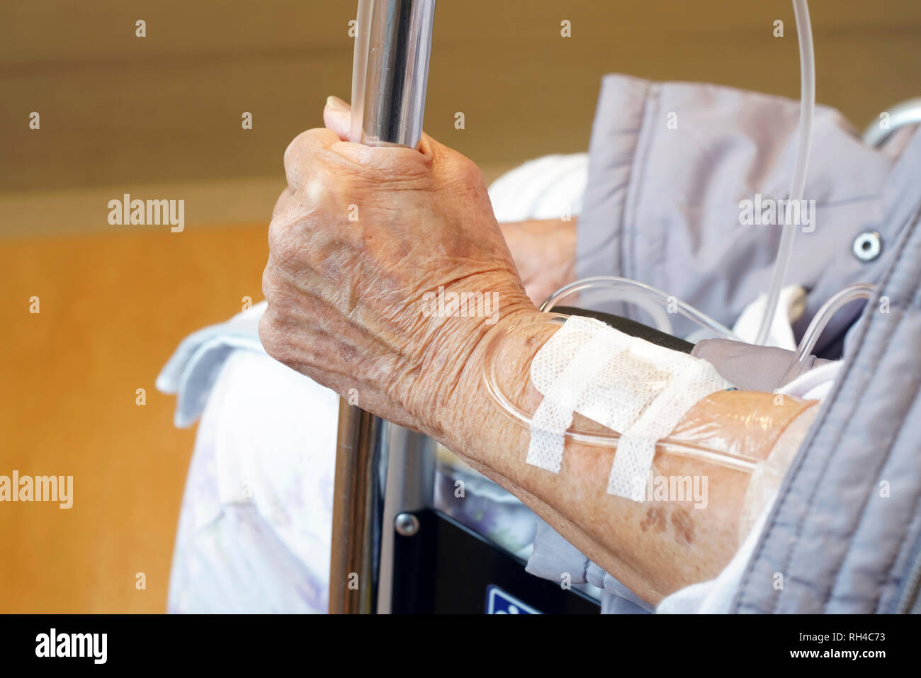 Close up of elderly woman hands with intravenous drip on a wheelchair at hospital Stock Photo