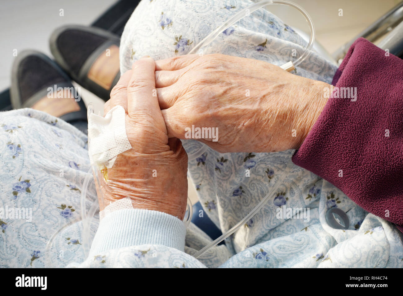 Close up of elderly woman hands with intravenous drip on a wheelchair at hospital Stock Photo