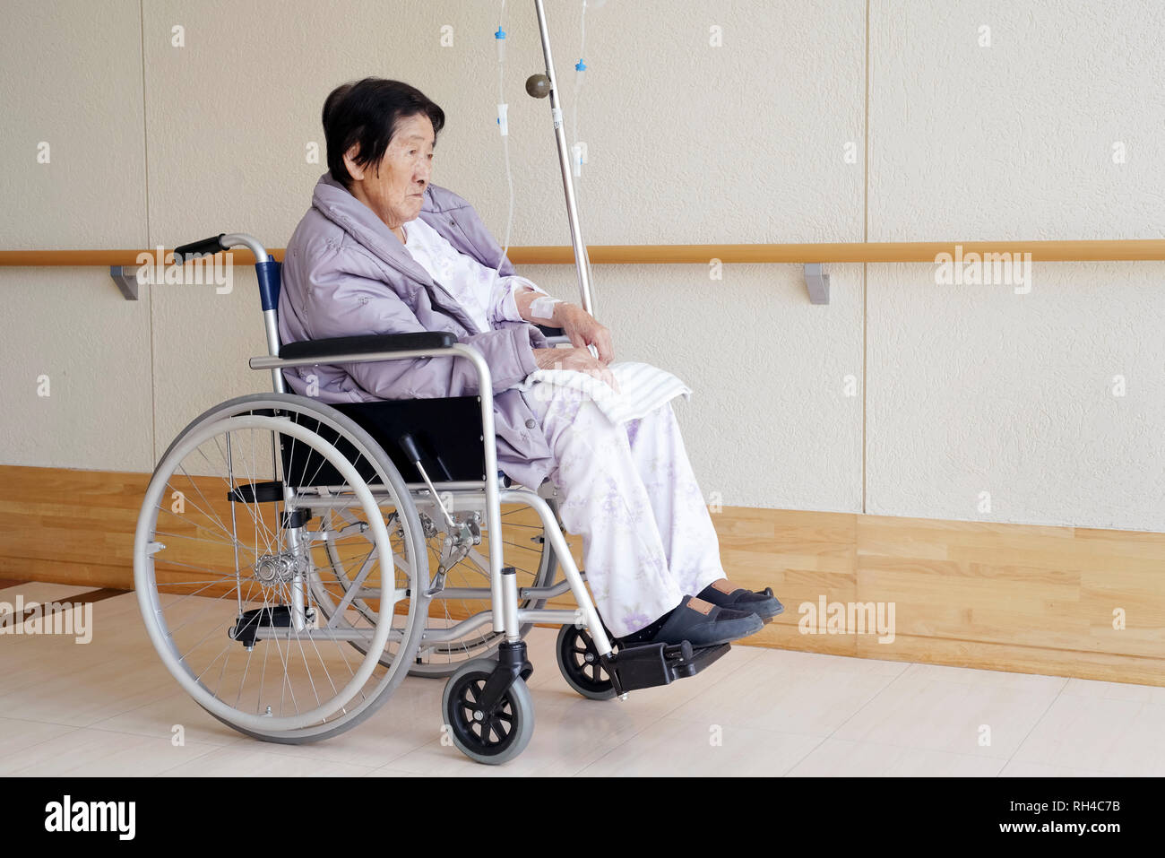 Senior or elderly woman patient on wheelchair so sad in hospital hallway Stock Photo