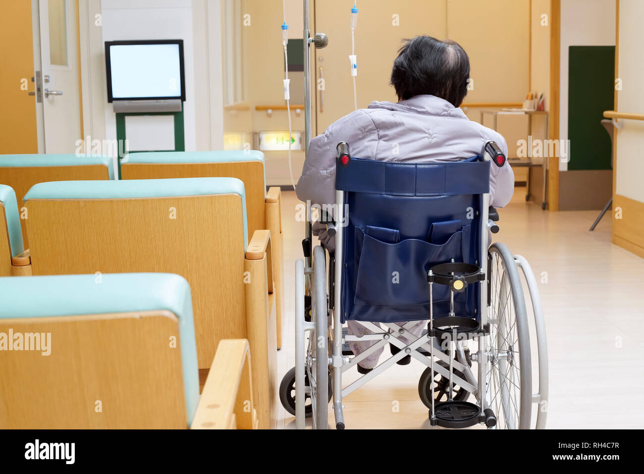 Back view of senior woman sitting on wheelchair in hospital Stock Photo