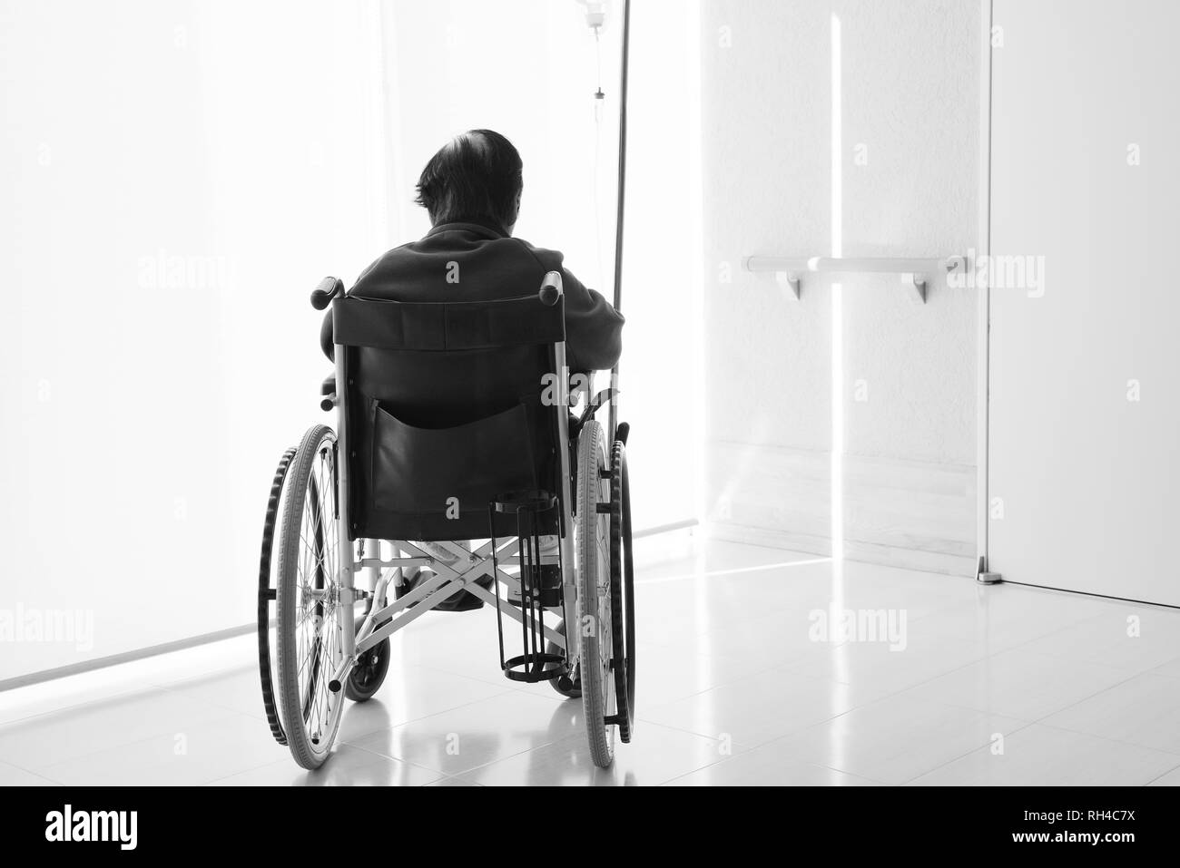 Senior or elderly woman patient on wheelchair so sad in hospital hallway Stock Photo