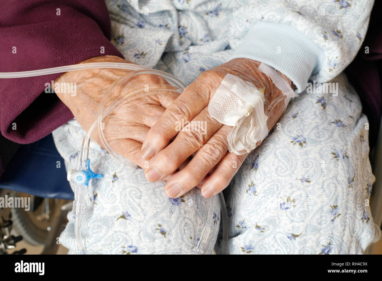 Close up of elderly woman hands with intravenous drip on a wheelchair at hospital Stock Photo