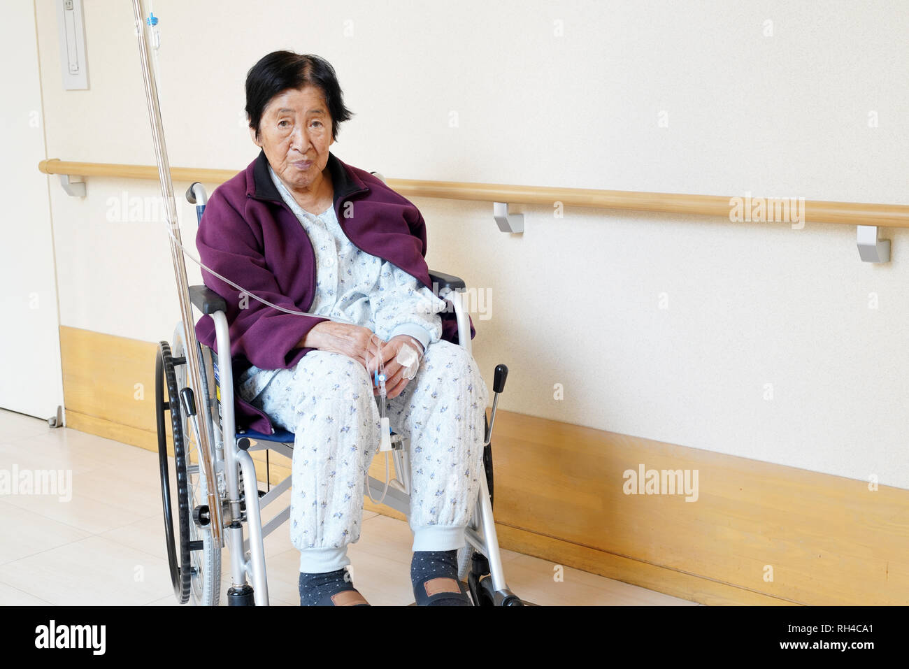 Senior or elderly woman patient on wheelchair so sad in hospital hallway Stock Photo