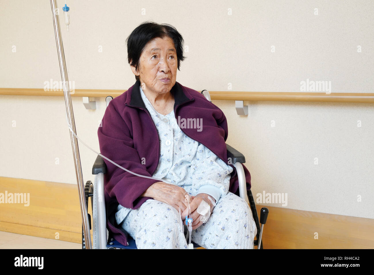 Senior or elderly woman patient on wheelchair so sad in hospital hallway Stock Photo