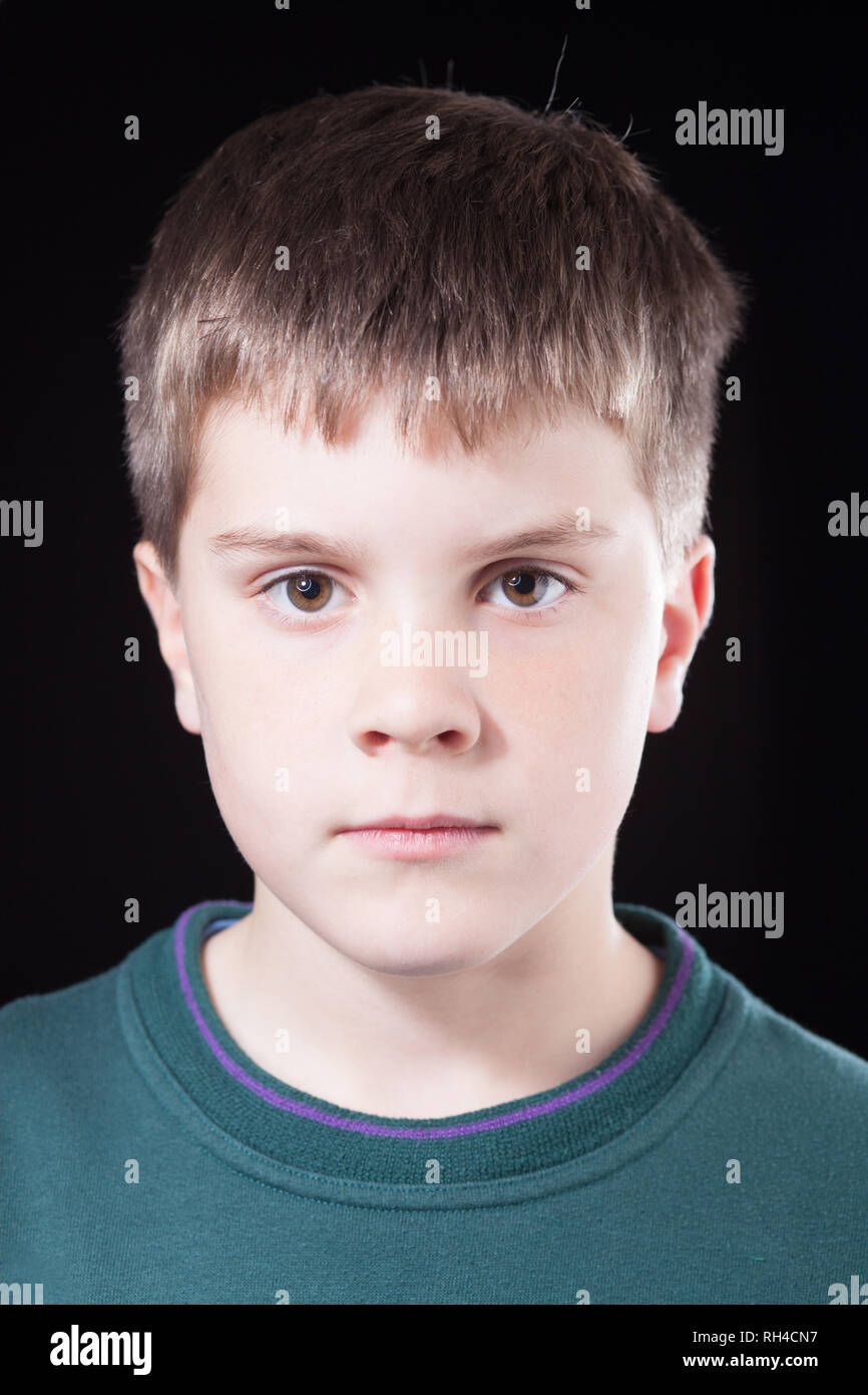 Studio shots of young boy with short brown hair, wearing green jumper Stock Photo