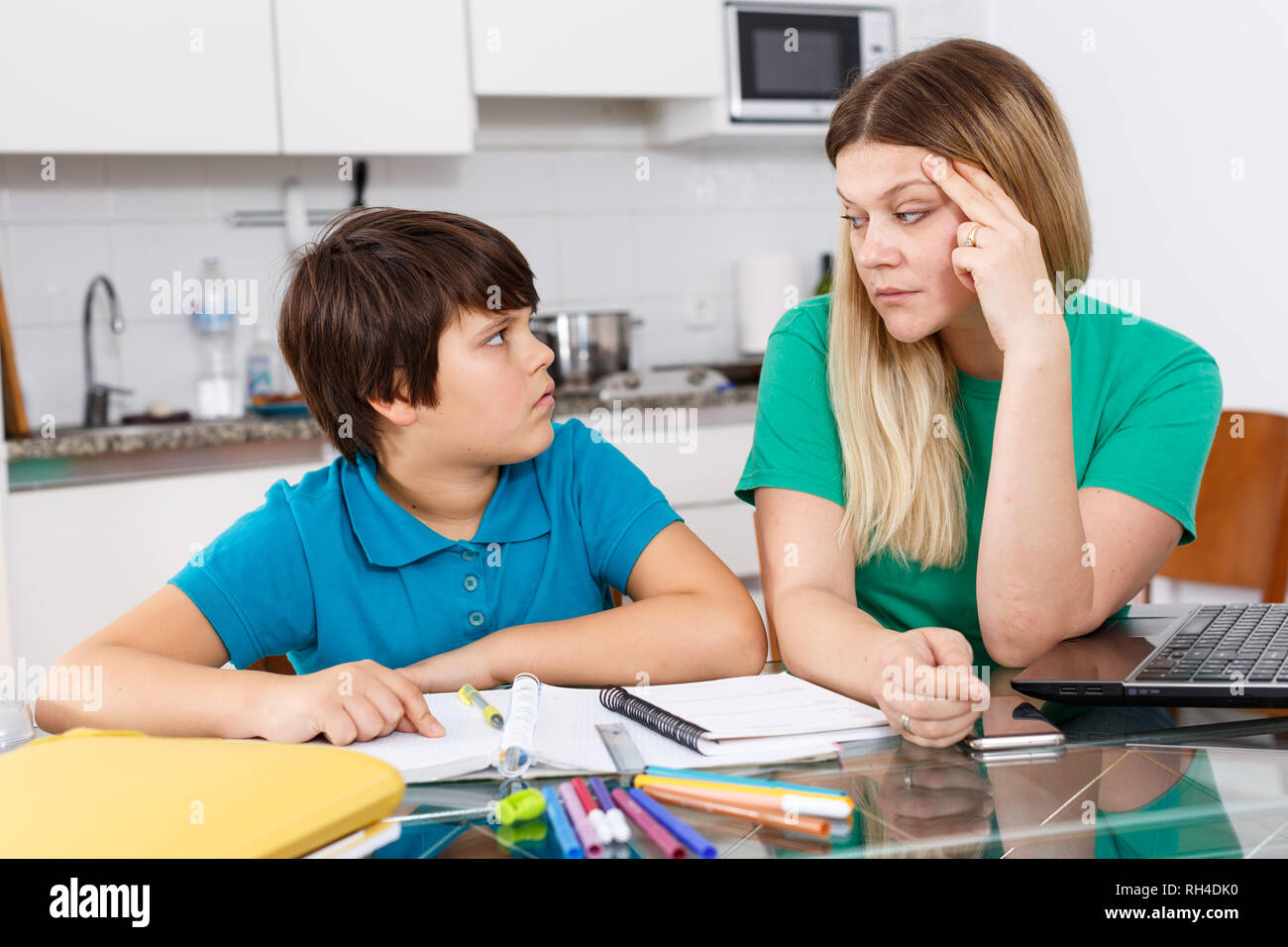 Displeased mother discussing with son his homewor Stock Photo