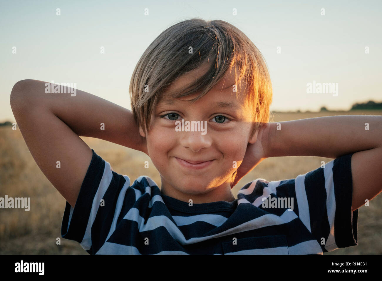 Portrait confident boy with hands behind head Stock Photo