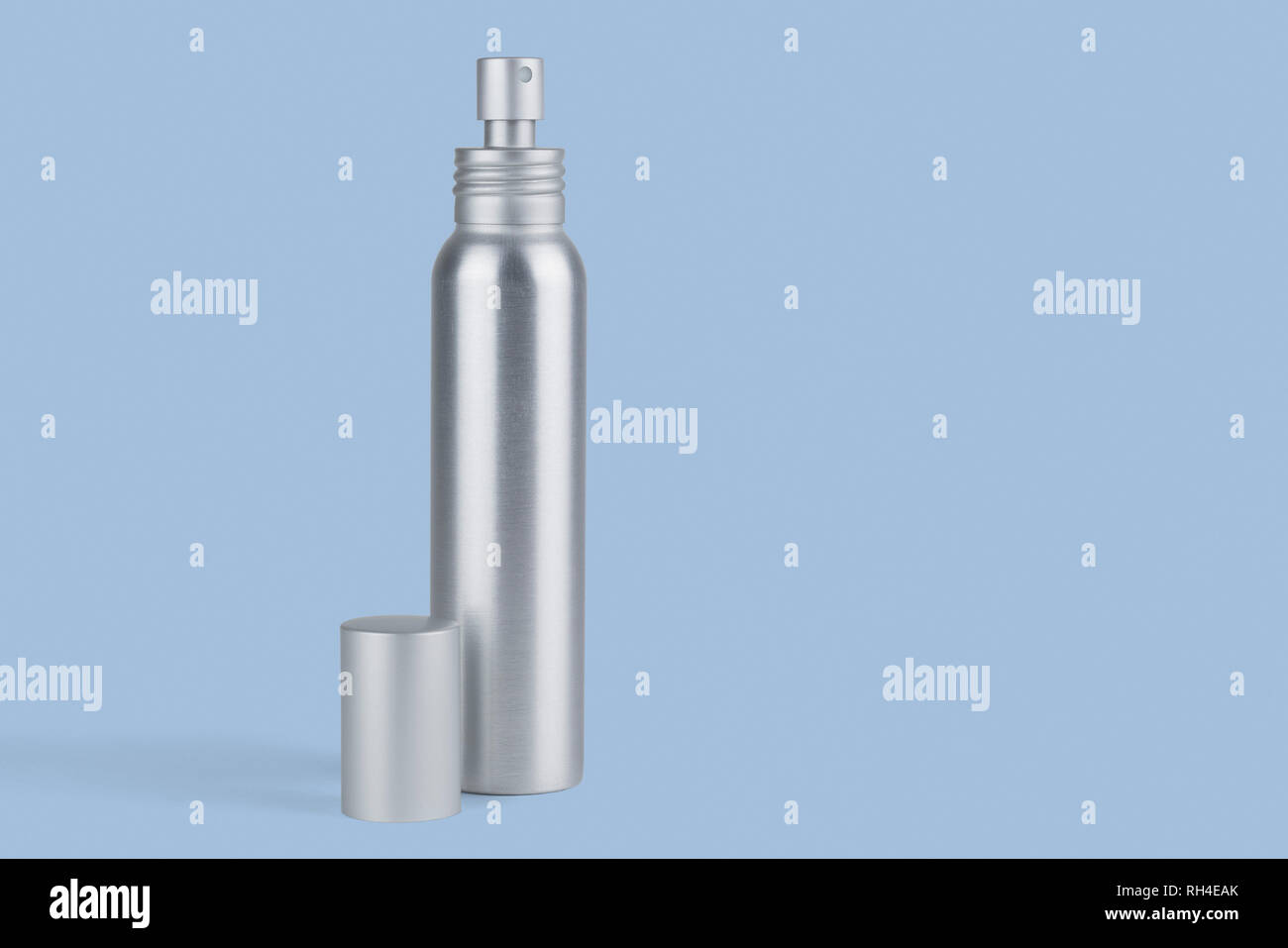 Metal spray bottle against blue background Stock Photo Alamy