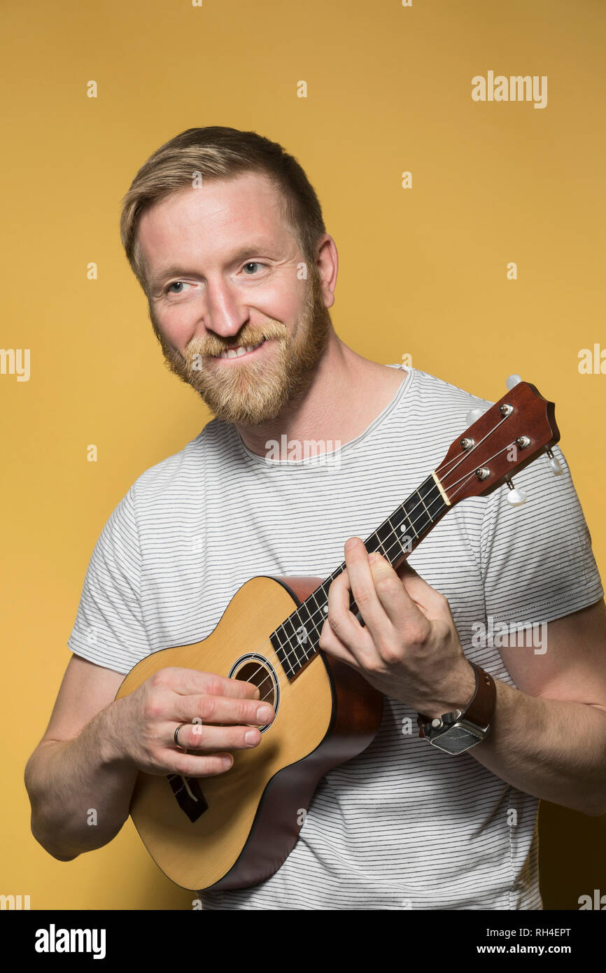 Portrait smiling man playing ukulele Stock Photo