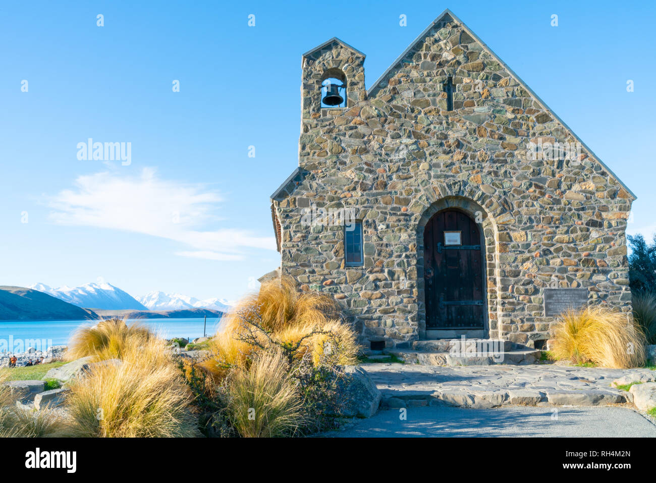 LAKE TEKAPO NEW ZEALAND - OCTOBER 14 2018; iconic small stone church Church of Good Shepherd against background aqua lake and scenic snow capped South Stock Photo