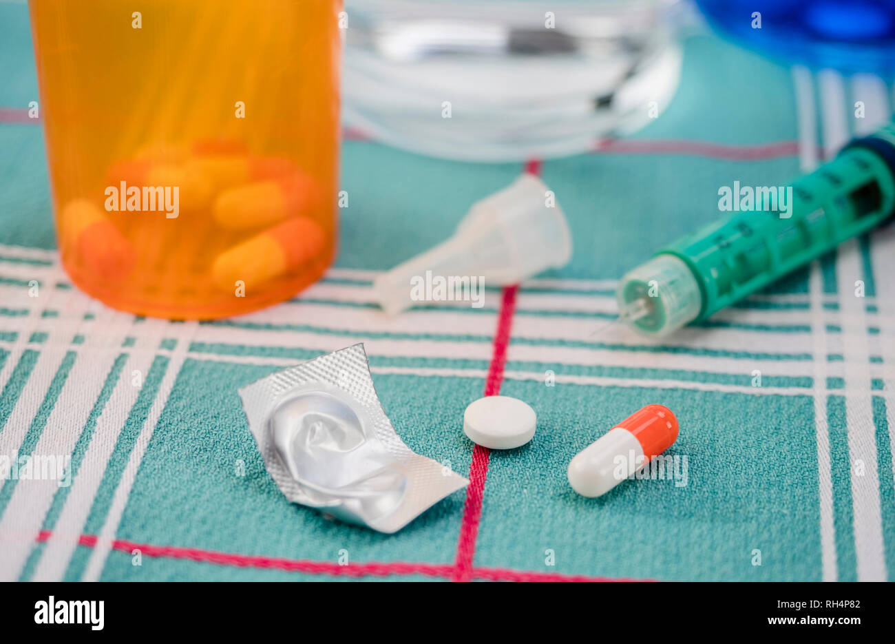Orange and white capsule along dispenser of insulin, conceptual Image