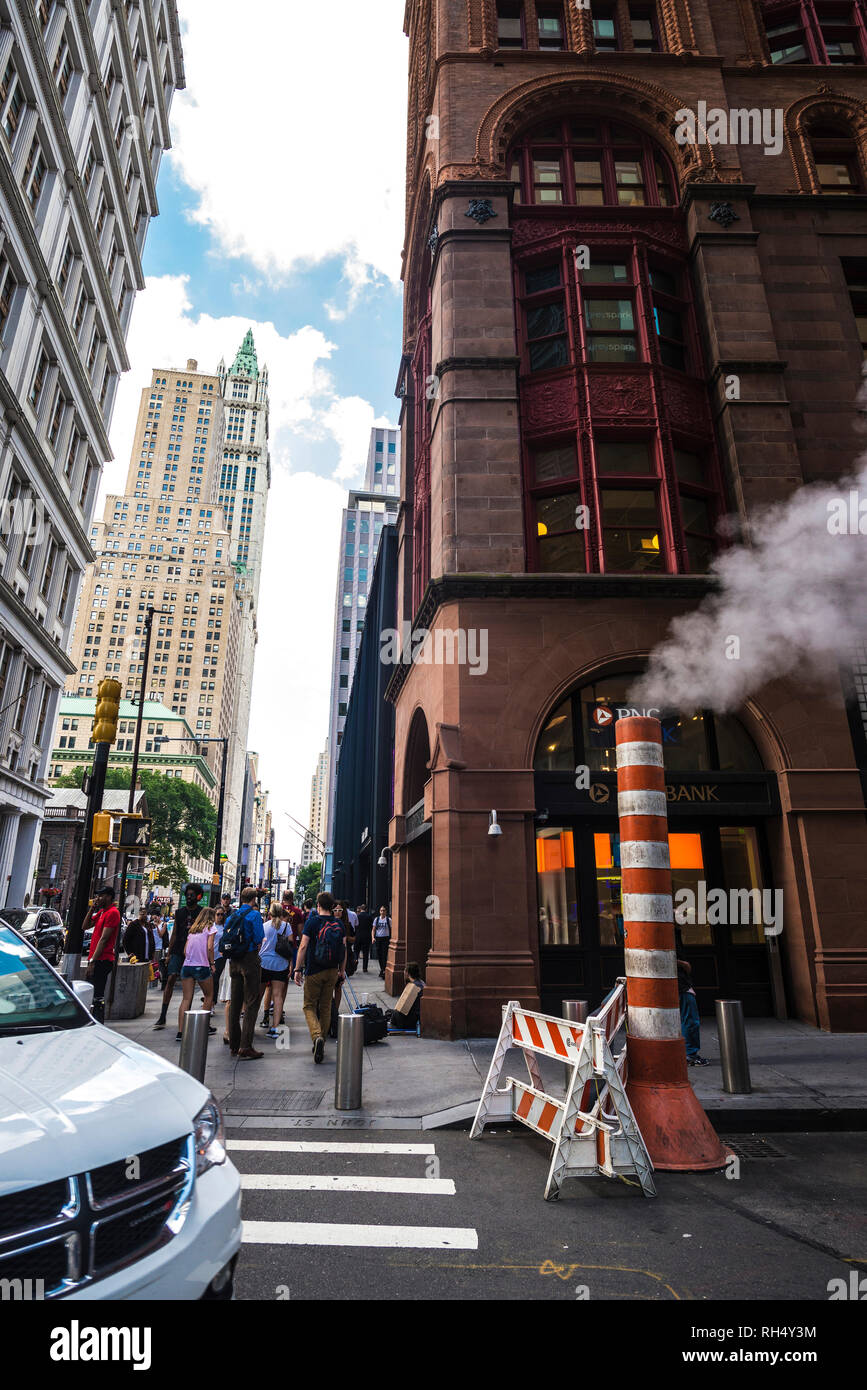 New York City, USA - July 26, 2018: Orange and white smoke stack steam pipe with people around in Manhattan in New York City, USA Stock Photo