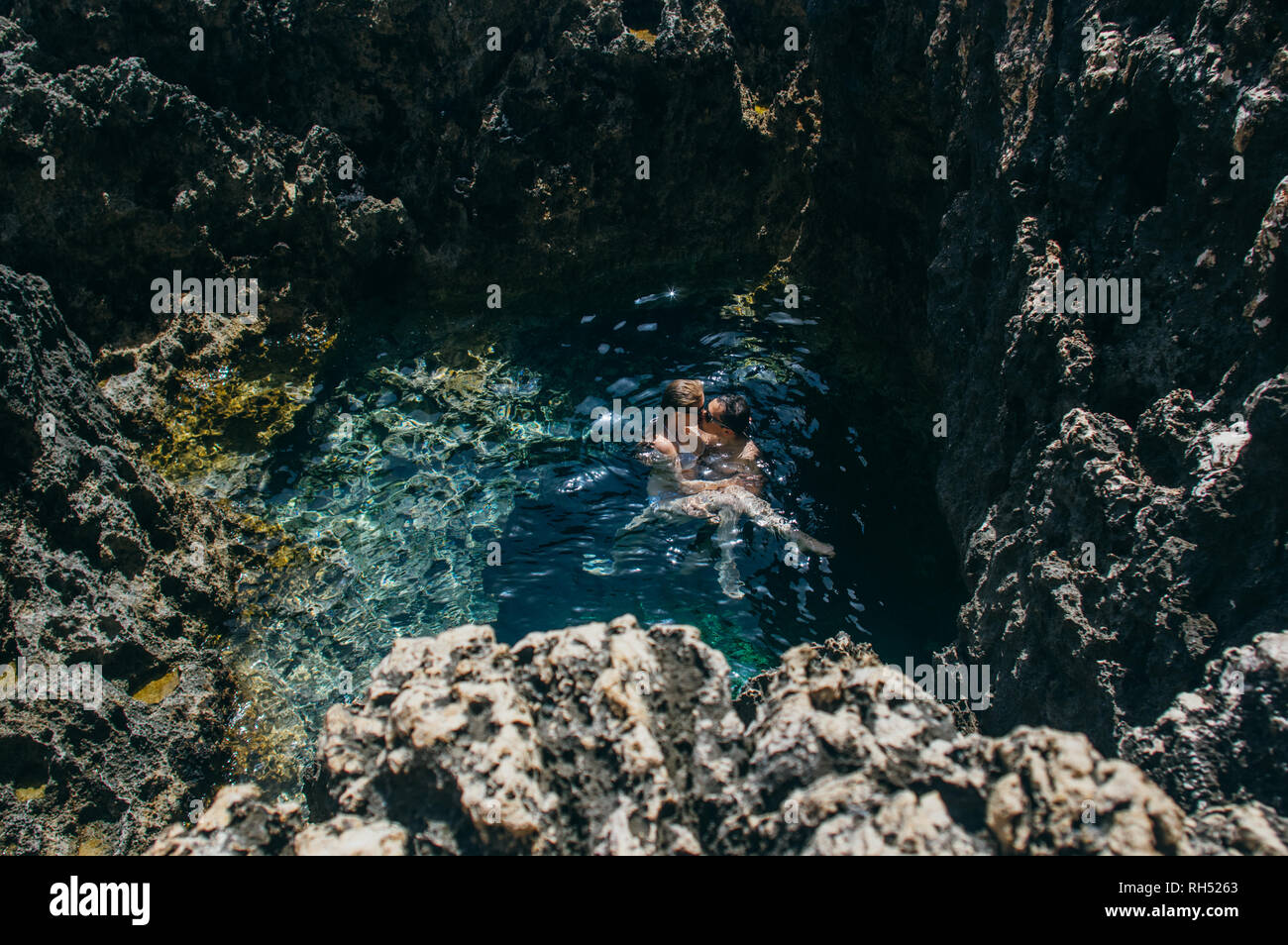 Man and woman together swimming and kissing in the pool, Malta Stock Photo