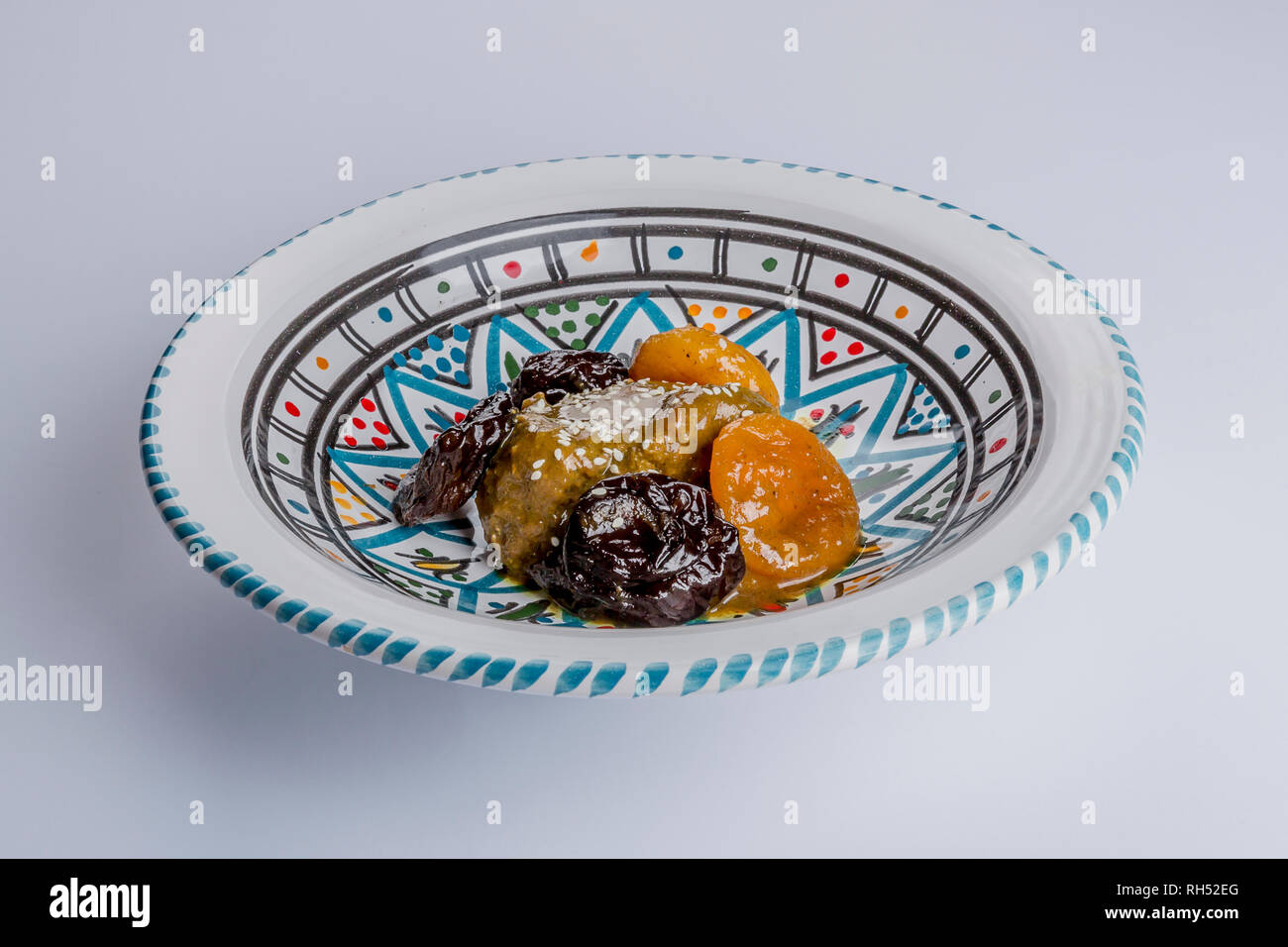 ceramic plate with multicolor decoration with a delicious moroccan sweet dessert with prunes and dried apricots Stock Photo