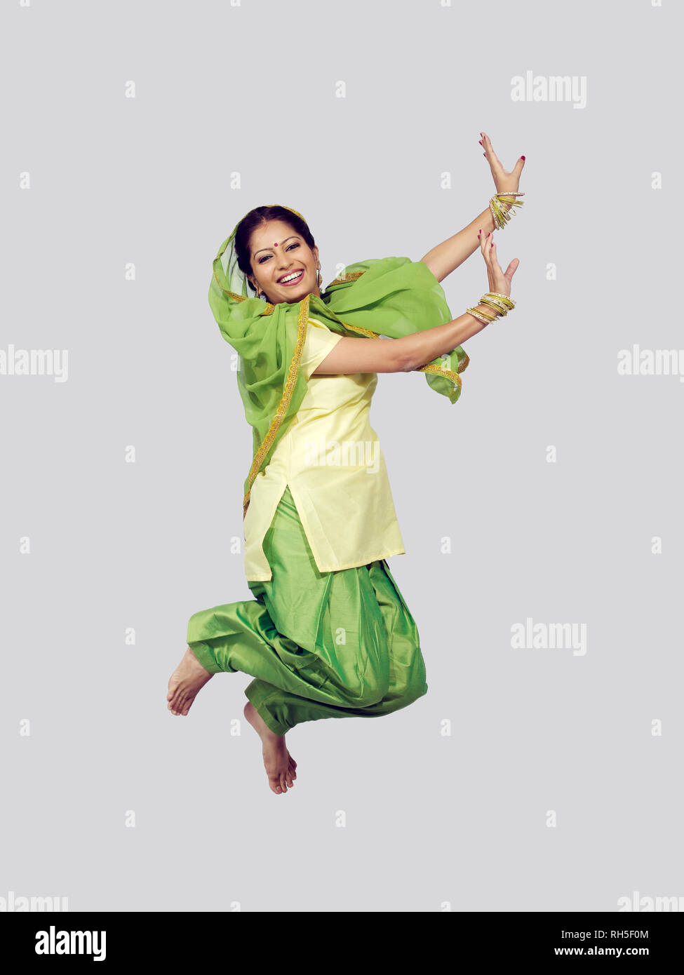 PORTRAIT OF A SARDARNI, SIKH WOMAN JUMPING DANCING THE BHANGRA Stock Photo