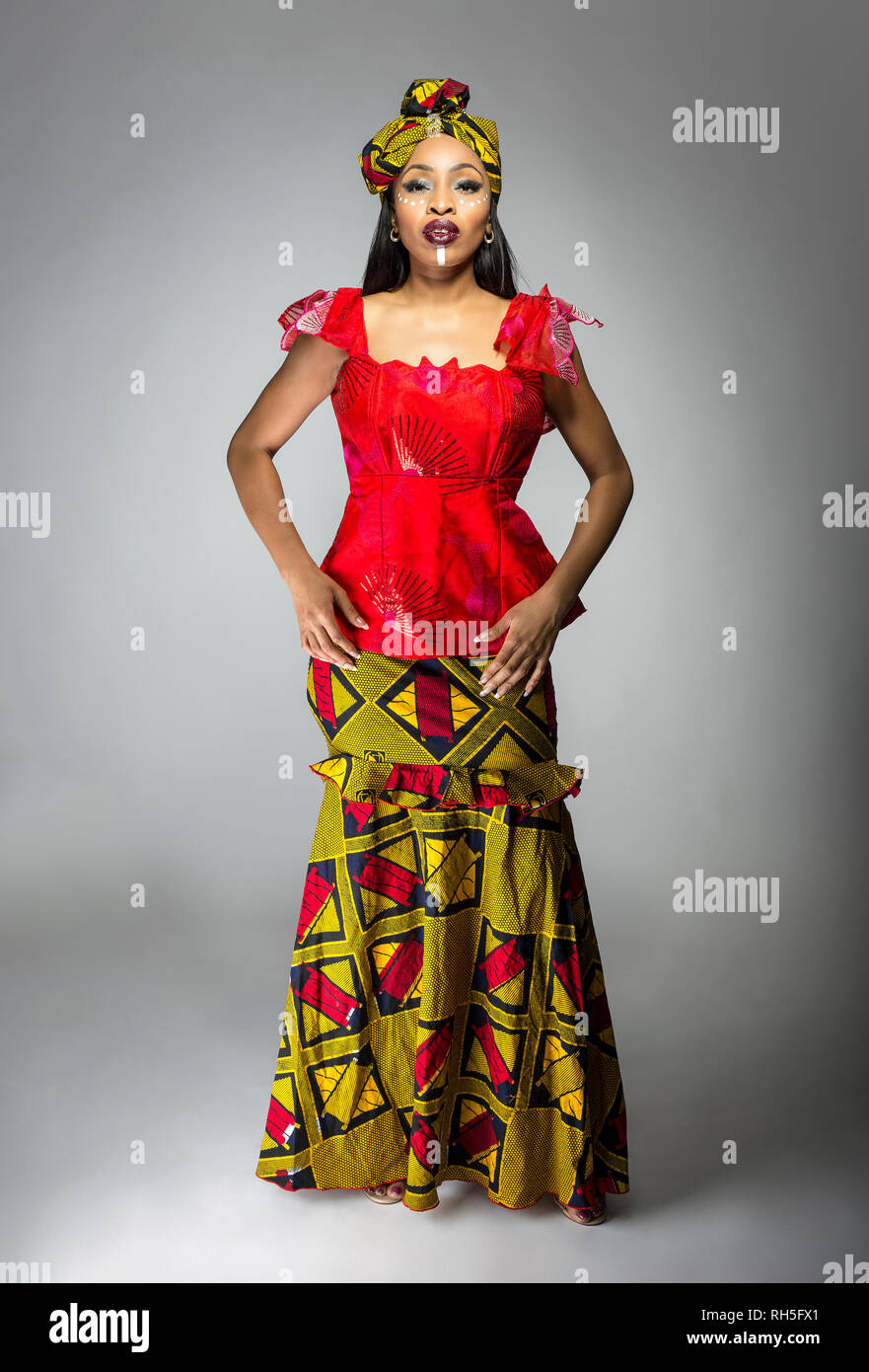 Black female showing african pride by wearing a traditional Nigerian dress  and head scarf with tribal face markings or cosmetic makeup. The costume i  Stock Photo - Alamy