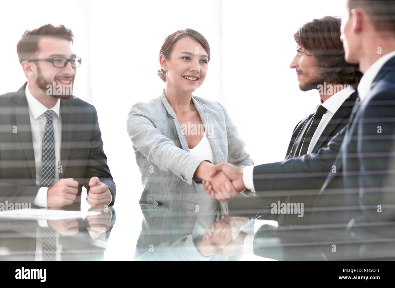 from behind the glass.handshake business people Stock Photo Alamy